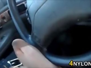 Подигравателен тя нозе в чорапогащник в а кола